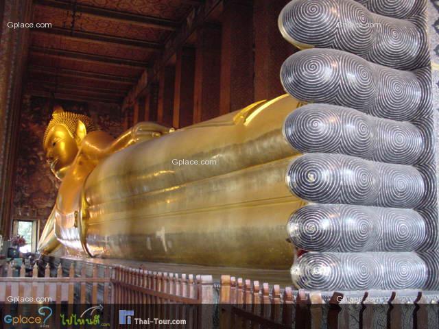 The image of reclining Buddha is 15 m high and 43 m long with his right arm supporting the head with tight curls on two box-pillows of blue, richly encrusted with glass mosaics.